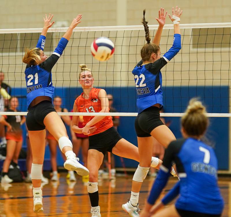 Wheaton Warrenville South's Lauren Coyne (13) watches her kill attempt sail past Geneva’s Grace Waters (21) and Charlotte Potvin (22) during a volleyball match at Geneva High School on Tuesday, Sep 5, 2023.