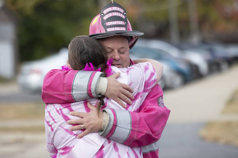 Pink Heals Sauk Valley Chapter director Brian Tribley hugs Peggy Craft Wednesday, Oct. 23, 2024, outside of Washington School in Sterling. The school came out in full support of their teacher’s aid who is battling cancer.