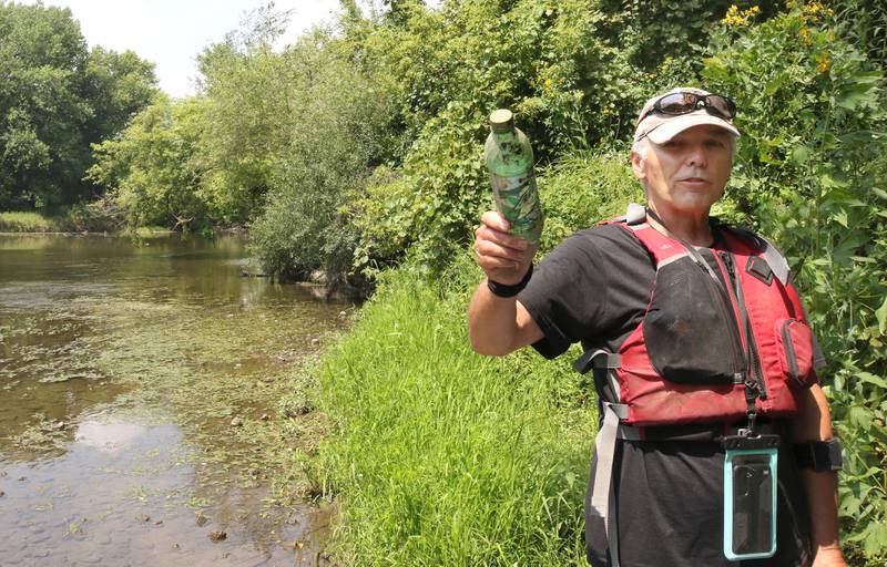 Greg Romaneck talks as he holds a plastic bottle he picked up Thursday, Aug. 10, 2023, about taking care of our natural environment along the banks of the Kishwaukee River at the Knute Olson, Jr. Forest Preserve in Kingston. Romaneck has been making regular visits to pick up trash as he paddles the river and been an advocate for keeping the river and its surroundings free of pollution.