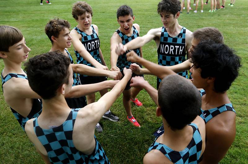 Woodstock North runners cheer before the start of the boys race of the McHenry County Cross Country Meet Saturday, August 27, 2022, at Emricson Park in Woodstock.