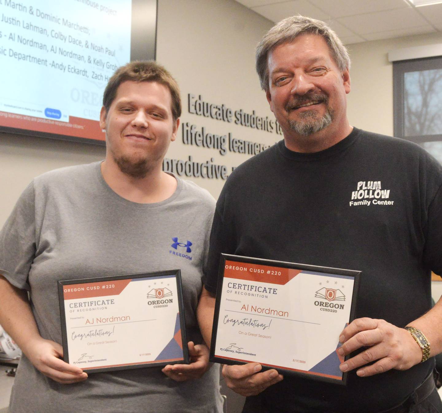 Oregon High School bowling coaches AJ Nordman and Al Nordman pose with the certificates they received from the Oregon School Board on Monday, March 17, 2025 in recognition of the Hawks' 12th place finish at state.