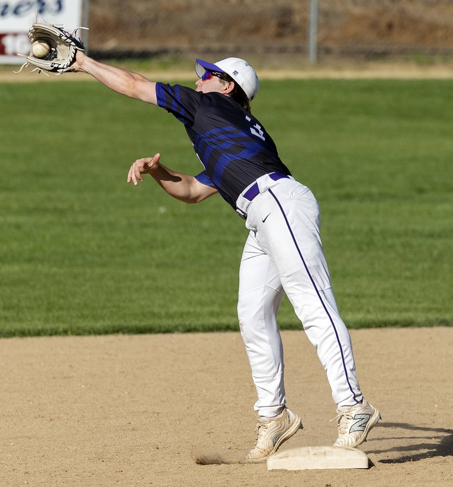 Dixon’s Jake Zepezauer reaches for a throw and keeps his foot on the bag for an out against North Boone Tuesday, May 6, 2025.