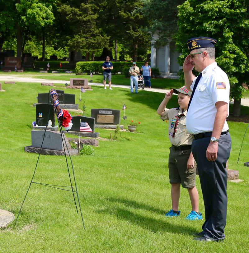 An Elburn Cub Scout along with Elburn American Legion member John Nevenhoven salute a wreath that was laid in the Memorial Day Ceremony at Blackberry Cemetery in Elburn on Monday, May 30, 2022.