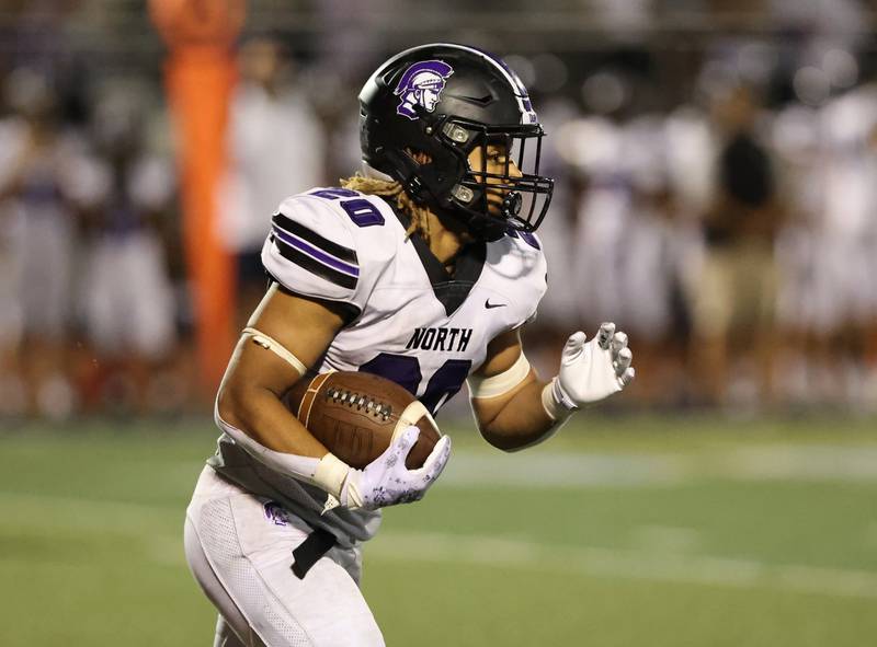 Downers Grove North’s Noah Battle (20) runs the ball against Downers Grove South during the boys varsity football game on Friday, Sept. 1, 2023.