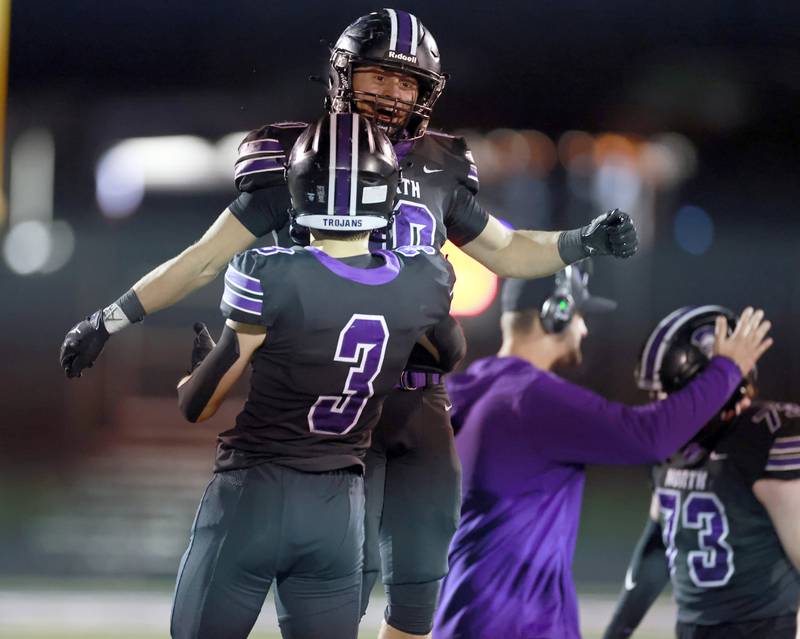 Downers Grove North's Oliver Thulin  (10) celebrates their win with Jonathan Nelson (3) during the IHSA Class 7A playoff football game Friday, Oct. 31, 2025 in Downers Grove.