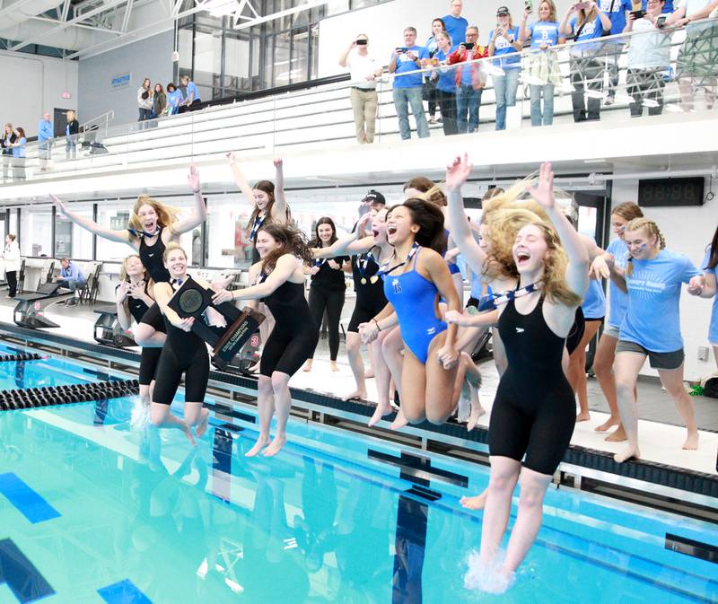 Rosary swimmers celebrate their first place win in the IHSA Girls State Championships on Saturday, Nov. 16, 2024 by jumping into the pool at FMC Natatorium in Westmont.the IHSA Girls State Championships on Saturday, Nov. 16, 2024 at FMC Natatorium in Westmont.