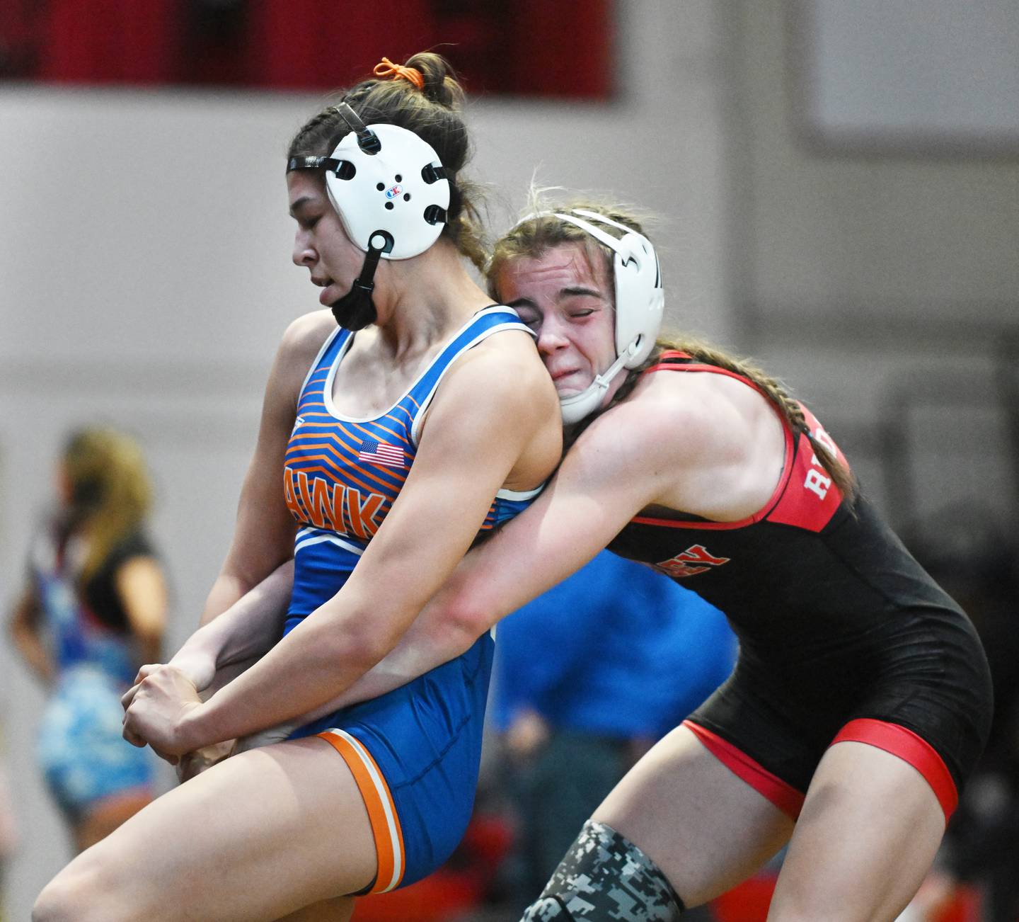 Hoffman Estates’ Sophia Ball, left, tries to escape the grasp of Huntley’s Aubrie Rohrbacher in the 130-pound final during the Schaumburg girls wrestling sectional Saturday.