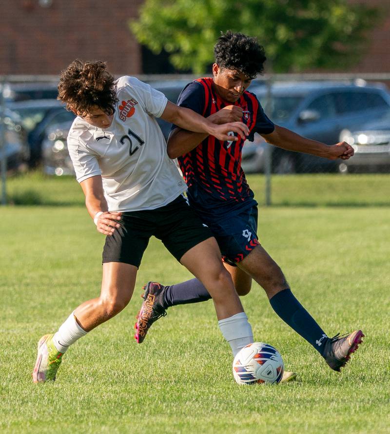Wheaton Warrenville South's Aaron Escareno (21) challenges Oswego’s Jersaih Avalos (9) for the ball during a soccer match at Oswego High School on Thursday, Aug 25, 2022.