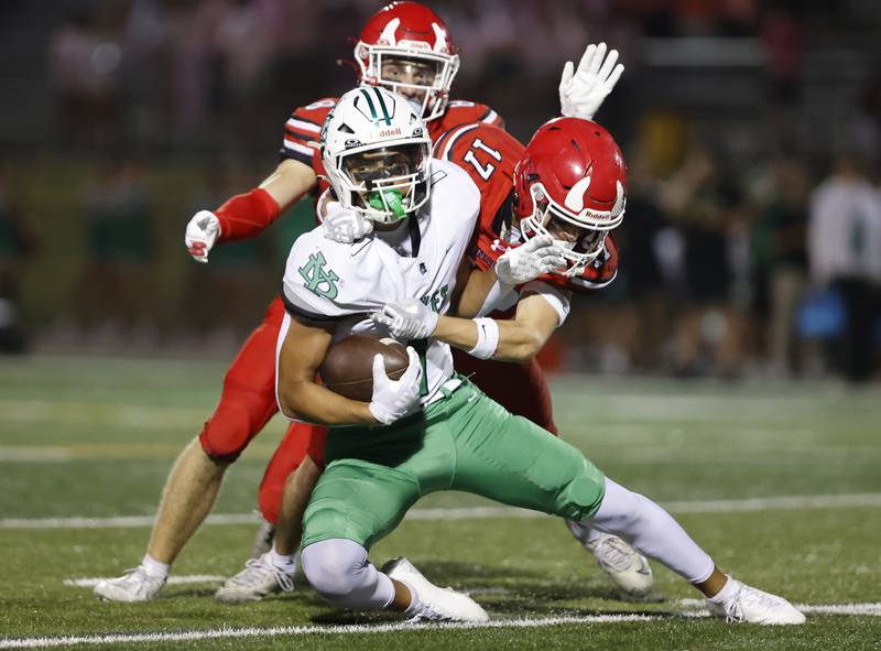 York's Simon Kodosky (1) is wrapped up by Hinsdale Central's CHarles Novatney (17) during the varsity football game between York and Hinsdale Central on Friday, Oct. 3, 2025 in Hinsdale, IL.