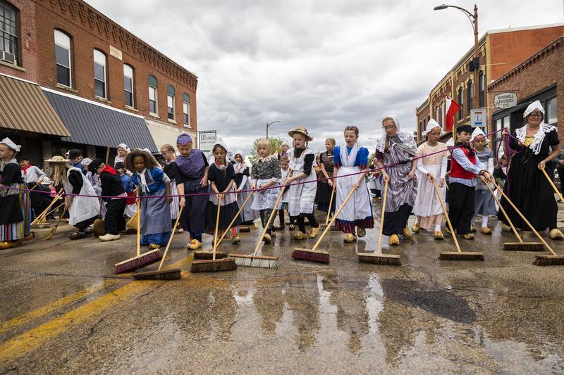 With brooms in hand, youngsters scrub clean the street Saturday, May 3, 2025, ahead of the Fulton Dutch Days parade.
