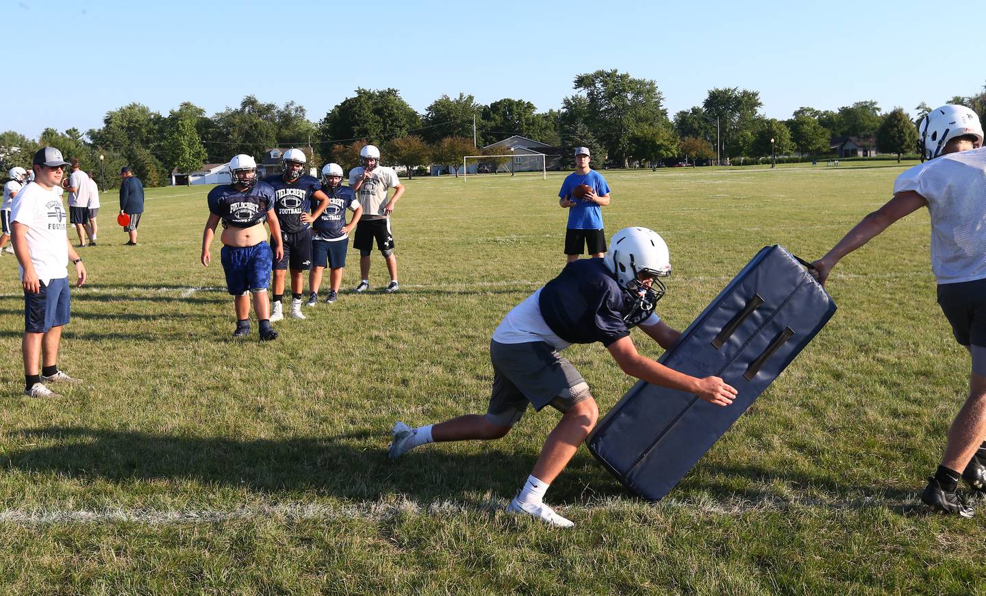 Members of the Fieldcrest football team work on strength and conditioning drills during football camp on Monday, July 18, 2022 at New Millennia Park in Minonk.