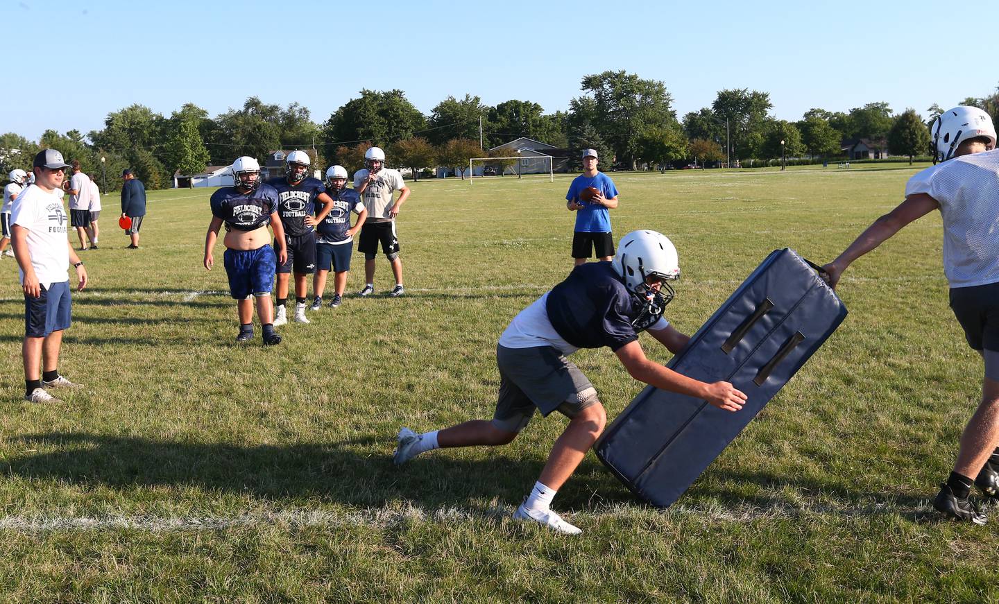 Members of the Fieldcrest football team work on strength and conditioning drills during football camp on Monday, July 18, 2022 at New Millennia Park in Minonk.