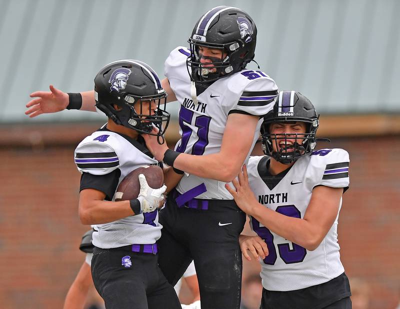 Downers Grove North’s Caden Chiarelli (4) celebrates his first touchdown of the game with Kasch Kuzelis (51) during a Class 7A second-round playoff game against Glenbard West on November 8, 2025 at Glenbard West High School in Glen Ellyn.