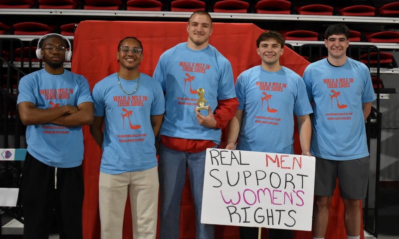 Participants pose for a photo at Safe Passage's annual Walk A Mile in Their Shoes event on April 18, 2026, at the Northern Illinois University Convocation Center in DeKalb. The event, held to raise awareness of sexual violence and supoprt survivors, was hosted by the nonprofit as part of Sexual Assault Awareness Month.