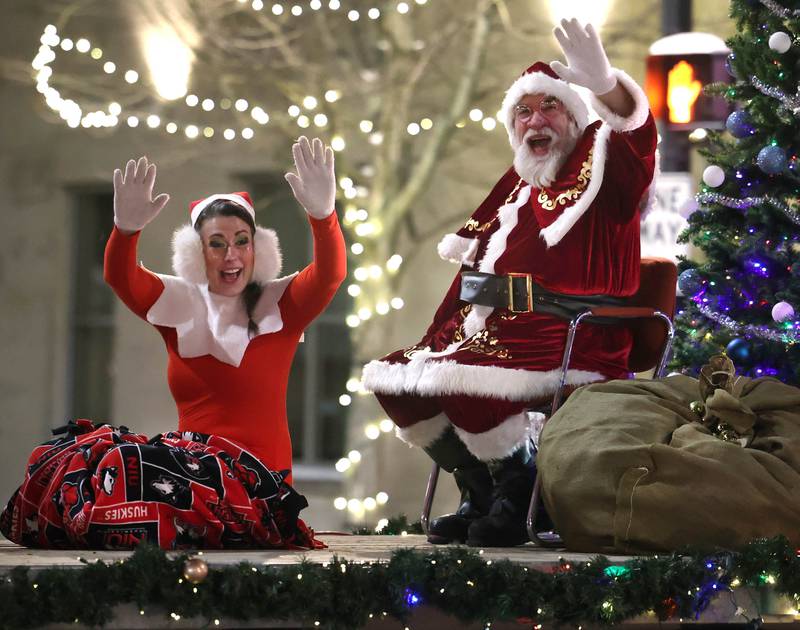 Santa Claus and his helper Elfie wave to kids as they make their way down Lincoln Highway Thursday, Dec. 4, 2025, during the annual Lights on Lincoln and Santa Comes to Town event hosted by the DeKalb Chamber of Commerce.