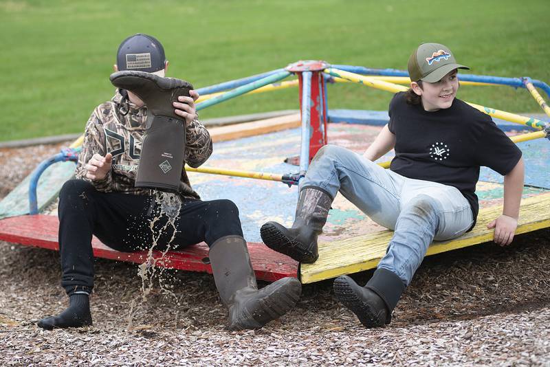 Connor Fritz, 11, drains his boot after working to pick up trash at Centennial Park Saturday. The Rock River Development Authority organized a day of cleaning along the canal in recognition of Earth Day.