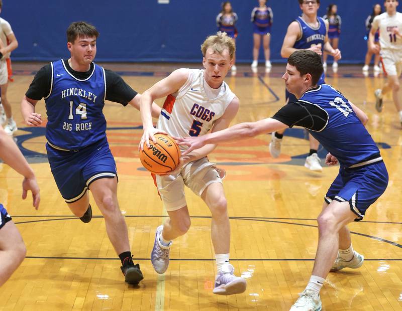 Genoa-Kingston's Blake Ides goes between two Hinckley-Big Rock defenders Tuesday, Jan. 6, 2026, during their game at Genoa-Kingston High School.