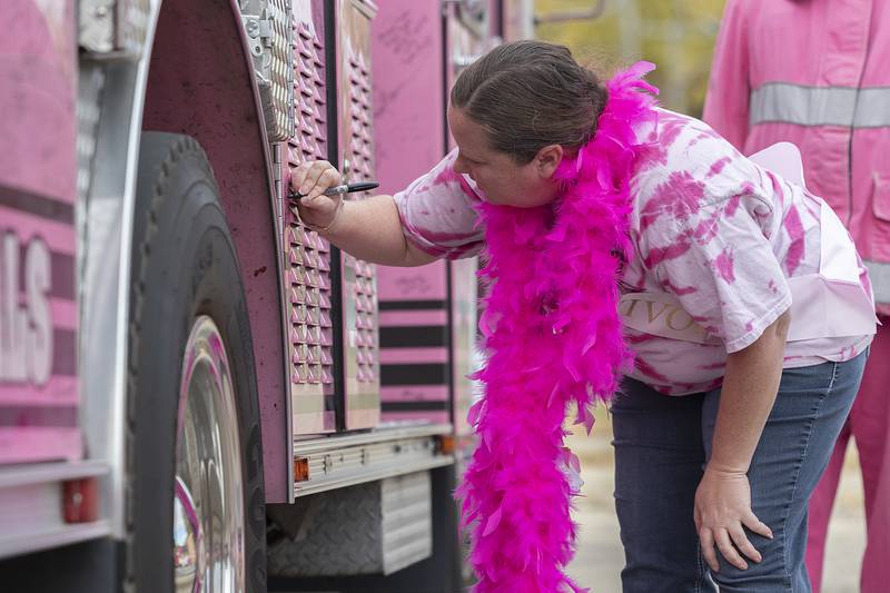 Peggy Craft signs the Pink Heals firetruck Wednesday, Oct. 23, 2024, in Sterling.