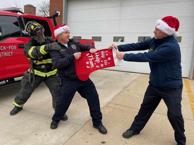 (From left): Little Rock-Fox Fire Chief Fred Kreinbrink (with an assist from firefighter Grant Kim) and Plano Police Chief Norm Allison engage in a friendly competition as they prepare to raise funds for needy families starting at 6:30 p.m. Friday, Dec. 6, 2024, during Plano’s 22nd Rockin’ Christmas event on Main Street.