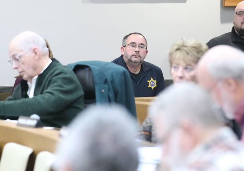 La Salle County Coroner Rich Ploch (center) listens as the La Salle County Board votes to purchase property at 520 W. Walnut St. in Oglesby for him and his staff to use for office space, getting them out of their cramped quarters in Ottawa. Ploch said it substantially advances his hopes for someday getting a morgue.
