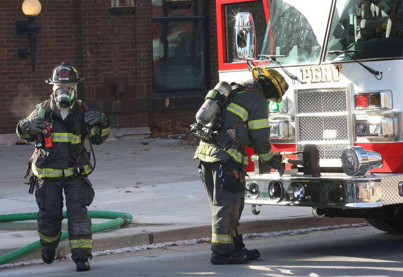 Peru Firefighters exit the Fire On Fifth entrance in the Westclox building on Tuesday, Jan. 20, 2026 in Peru. A working fire started in the storage room inside of Fire on Fifth. The fire started at 10a.m.  Fire departments from Utica, Oglesby Peru and La Salle all assisted on the scene. La Salle and Peru EMS were also dispatched. The entire Westclox building was evacuated. Two employees were transported by ambulance for smoke inhalation. A smoke detector inside Star Union Spirits triggered an alarm, prompting a fast response from firefighters.