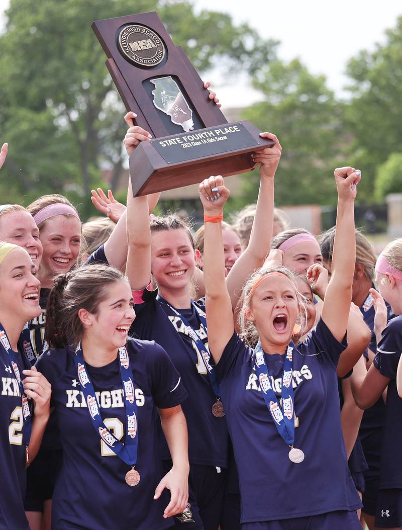 IC Catholic Prep players celebrate with their fourth place trophy after their loss to Pleasant Plains in the IHSA Class 1A state girls soccer third place game Saturday, May 27, 2023, at North Central College in Naperville.