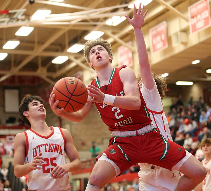 L-P's Seth Adams scores on a layup over Ottawa's Payton Knoll and Trace Roether in Kingman Gymnasium on Friday, Feb. 10, 2023 at Ottawa High School.