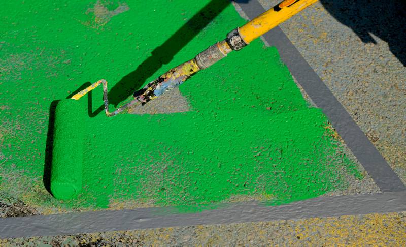 Green paint is applied to the street mural at the intersection of Walnut and Riverside Avenues as part of the St. Charles Art Council’s “Paint the Riverside” on Saturday, May 10, 2025 in St. Charles.