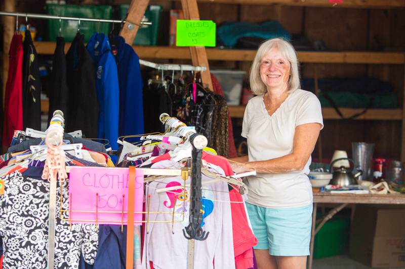 Connie Phistry stands near some of the clothing she placed for sale during Westmont’s weekend garage sales, Sunday, August 4, 2024.