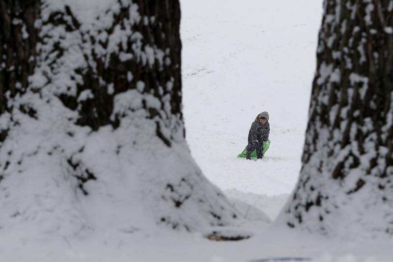 Javi Domingo, 6, of Cary, trudges up the hill after making a sledding run Wednesday, Jan. 25, 2023, at Veteran Acres Park in Crystal Lake. Snow fell throughout the morning, leaving a fresh blanket of snow in McHenry County.