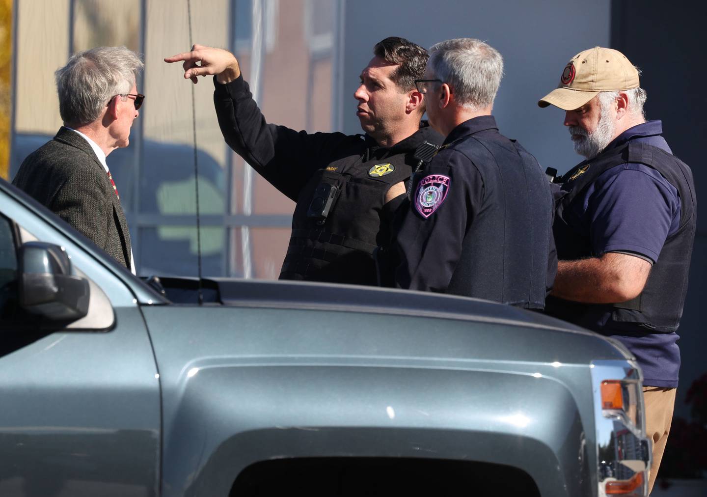 Law enforcement officers talk to DeKalb City Manager Bill Nicklas Wednesday, Oct. 23, 2024, outside of the Brian Bemis Toyota car dealership in DeKalb after responding to a stabbing where multiple employees were injured. The incident ended after police shot the man wielding the knife authorities said.