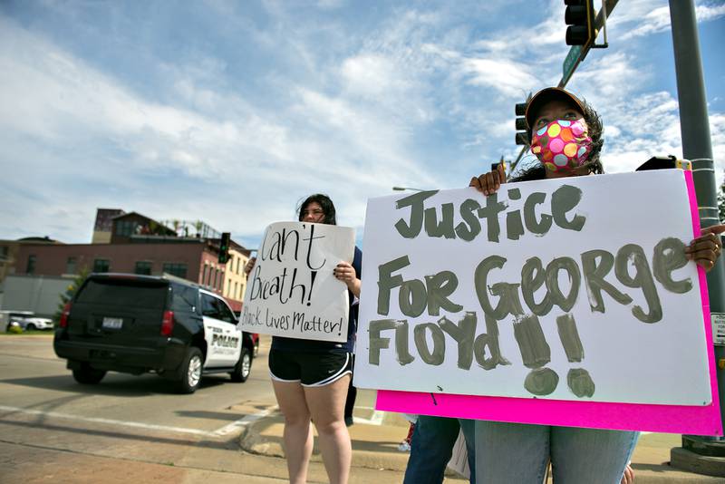 Megan Sweeney (right) and Tayla Schwarz display signs during a protest in Dixon denouncing the killing of George Floyd by a Minneapolis police officer.
