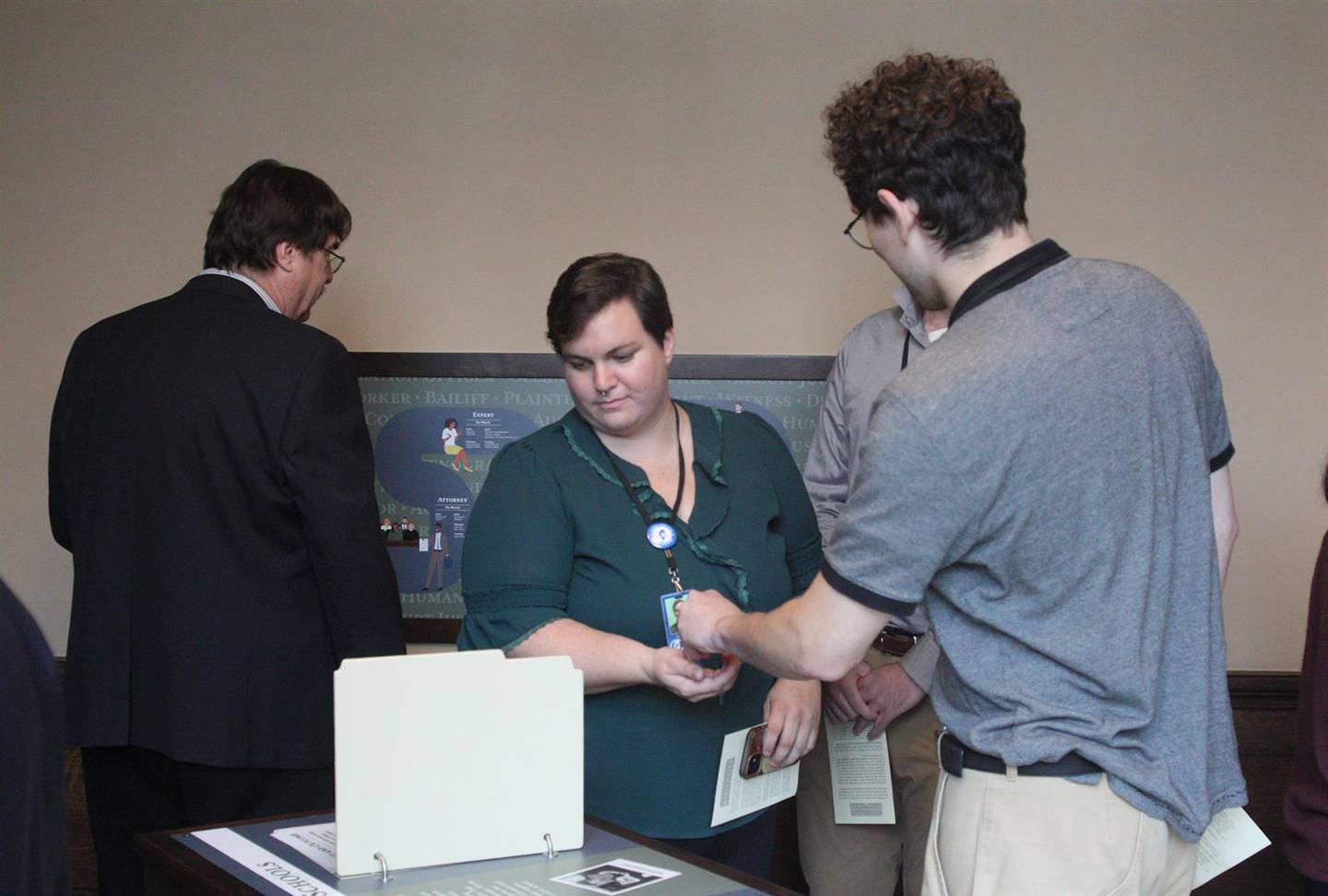 Attendees of a grand opening event sample some of the interactive exhibits at the new learning center in the Illinois Supreme Court building in Springfield. This exhibit tells the story of one controversial case and invites people to indicate whether they agree or disagree with the court's ruling.
