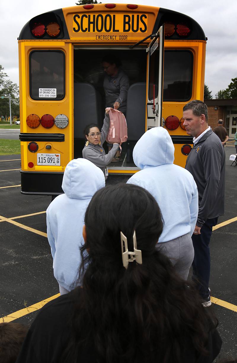 Gabi Ordonez hands out backpacks during a Woodstock School District 200 Back to School Coming to You event at Northwood Middle School on Tuesday, Aug. 6, 2024. The location was one of twelve stops on the tour that gave out backpacks and school supplies, provided registration help and computer repair.