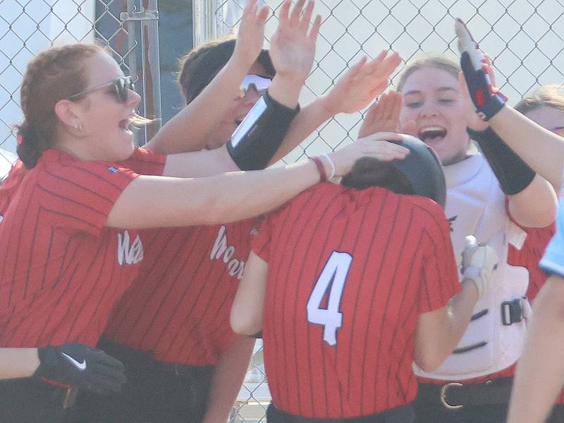 Members of the Henry-Senachwine softball team greet teammate Alaina Sprague at home plate after hitting a home run against Marquette on Thursday, April 23, 2026 at June Cross Field in Ottawa.