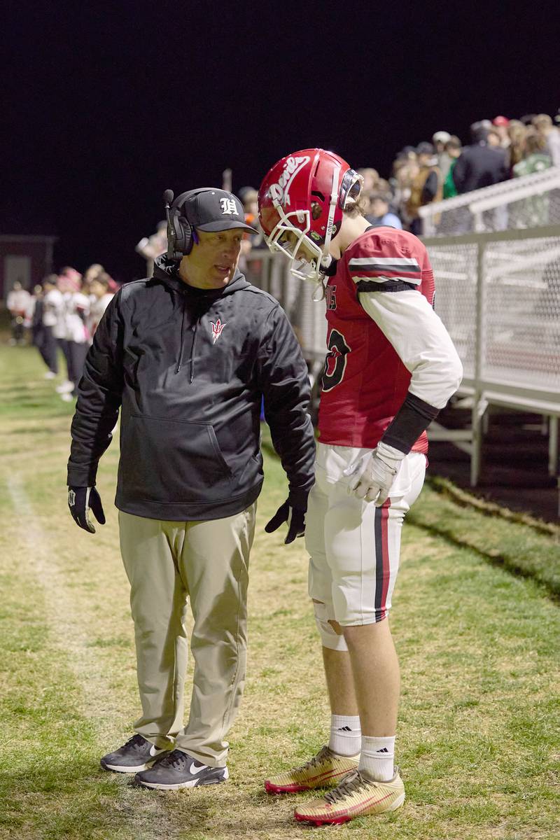 Hall assistant coach Mike Filippini talks to player Chale Burkhart on Friday, Oct. 24, 2025 at Richard Nesti Stadium.