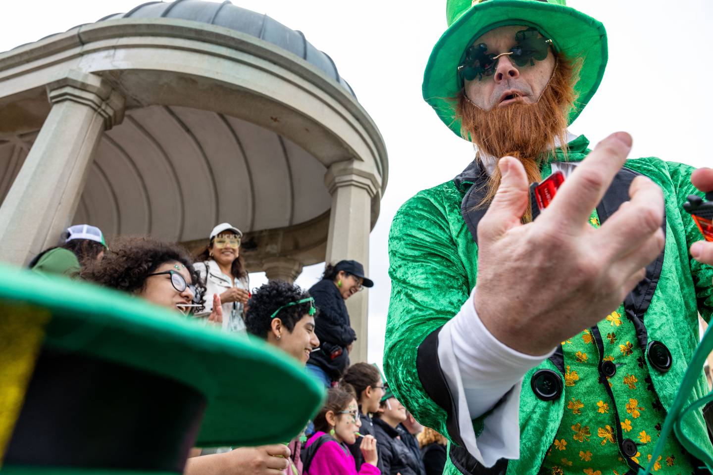 Matt Kombrink, of The Kombrink Team, hands magnets to parade attendees during the St. Charles St. Patrick’s Parade on Main Street in St. Charles on Saturday, March 15, 2025.