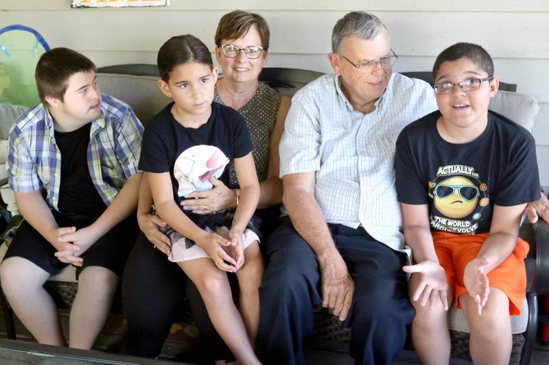 DeKalb County Sheriff Roger Scott, his wife Marcia, along with children David, (left) 15, and Evalina, 7, listen to Ashton, (right) 11, as he talks Tuesday about life in their DeKalb home. Through the years the Scott's have raised ten kids, seven adopted, all while as fostering over 40 children.