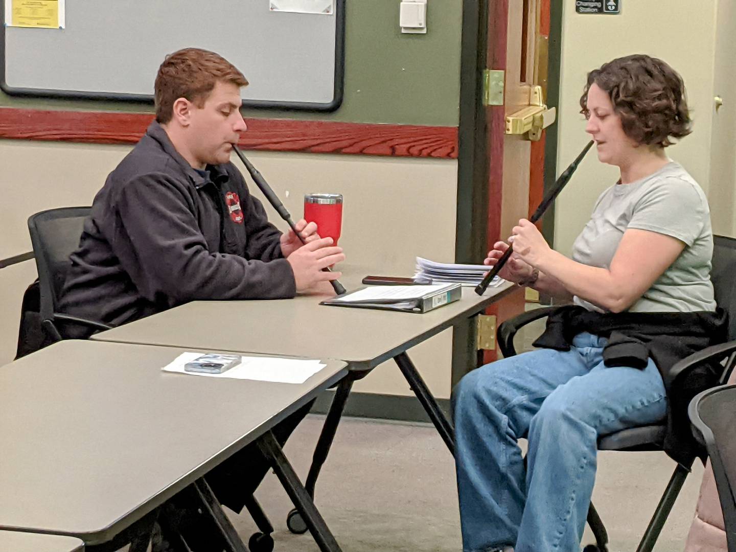 Music instructor Kate Longid, right, works with Oswego firefighter and bagpipe player Ryan Dunning, left, during a recent rehearsal.
