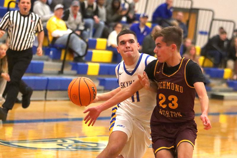 Johnsburg’s Ryan Franze, left, works past Richmond-Burton’s William Gardner on a fast break in varsity boys basketball onTuesday, Dec. 9, 2025, at Johnsburg High School in Johnsburg.
