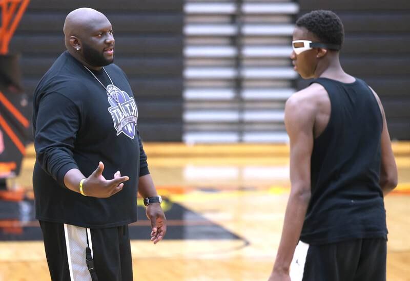 Jay Moore, founder of TRUTH Basketball Academy and an assistant basketball coach at DeKalb High School, gives Gabe Crump, 15, from DeKalb, some pointers Tuesday, June 25, 2024, during a session at the school.