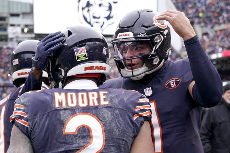 Chicago Bears quarterback Justin Fields, right, congratulates wide receiver DJ Moore after they hooked up on a touchdown pass during the second half against the Detroit Lions, Sunday, Dec. 10, 2023, in Chicago.