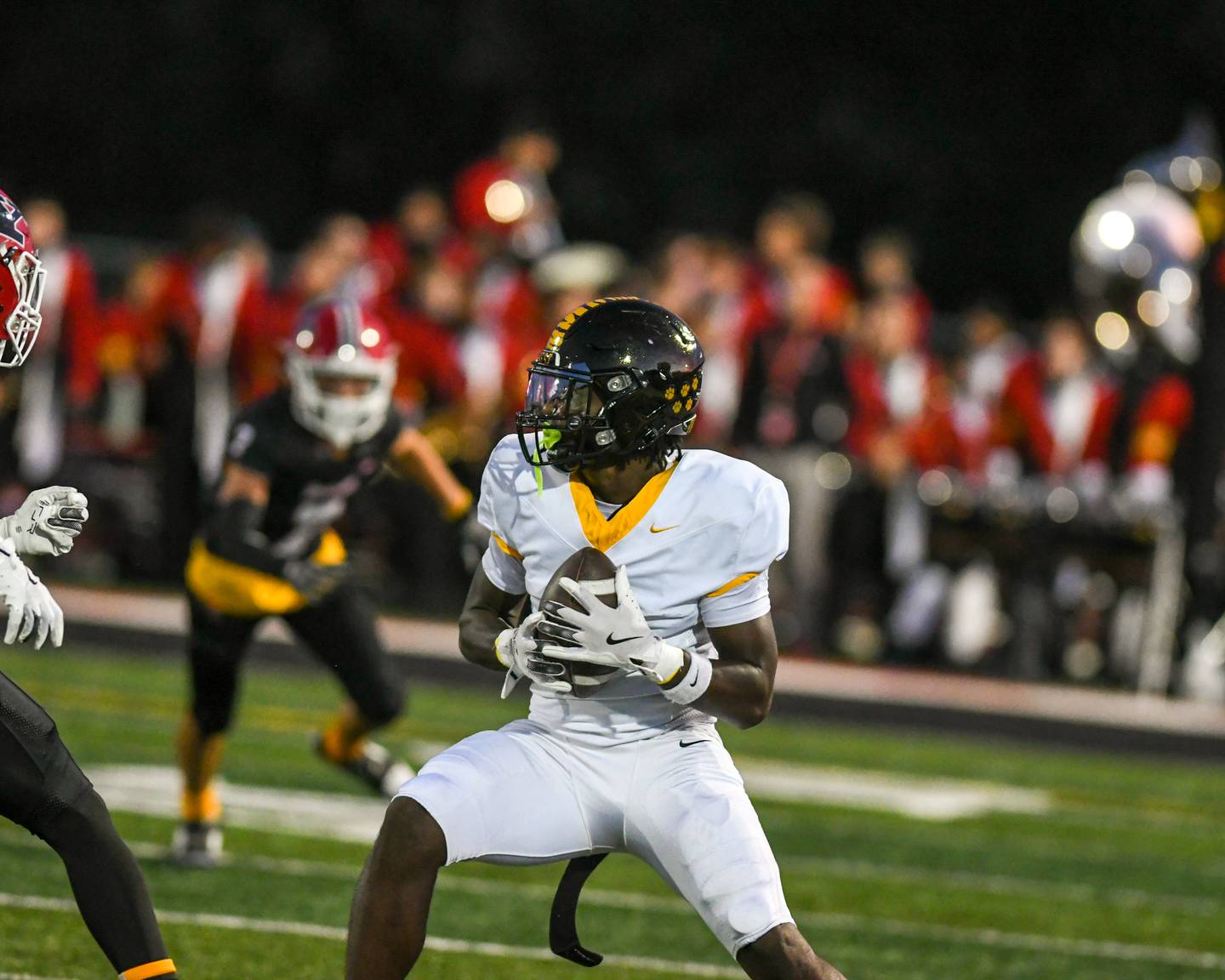 Joliet West's Jordan Bennett (1) catches the ball and gains some yards before being tackled by Yorkville players during the game on Friday Sept. 5, 2025, while traveling to Yorkville High School.