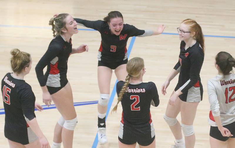 Members of the Woodland volleyball team react after scoring a point against Marquette on Thursday, Oct. 19, 2023 at Bader Gym.