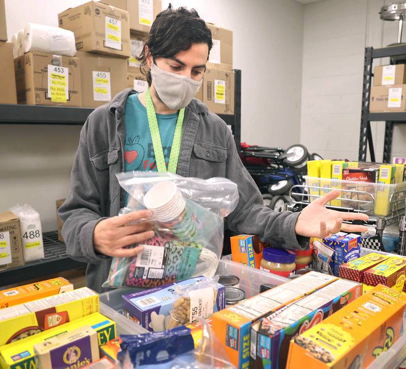 Frankie DiCiaccio, operations manager of Barb Food Mart, puts items on the shopping shelves Thursday, April 7, 2022, at the facility in DeKalb. Barb Food Mart is a food pantry serving those in need that have a student enrolled in the DeKalb School District.