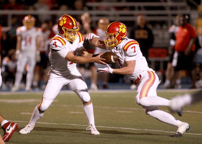 Batavia quarterback Bodi Anderson hands the ball off to Greyson Kelly during a game on Friday, Sept. 27, 2024 at Wheaton North.