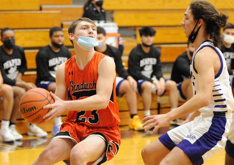 Sandwich's Chance Lange (23) looks for a teammate under the basket against Plano defender Josh Padilla on Monday, January 10, 2022, at Plano High School.
