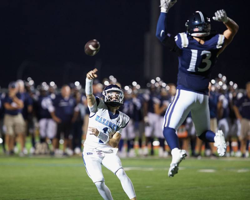 Nazareth's Logan Malachuck throws a pass as IC Catholic's JP Schmidt goes for the block on Friday, Sept.15,2023 in Elmhurst.