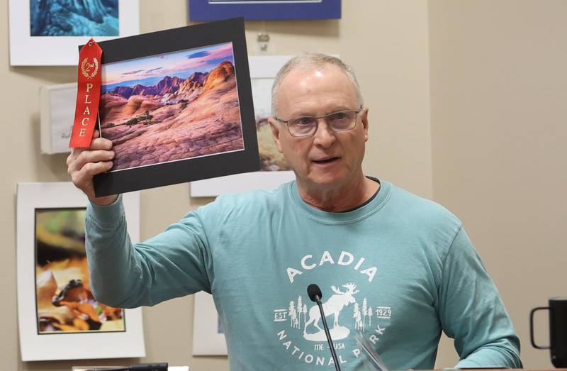 Ray Zborowski of Peru, holds a second place photo taken by his son Billy of Utah canyons with cotton candy sky during the Starved Rock Photography Show awards on Saturday, Jan. 3, 2026 at the Starved Rock Visitors Center.