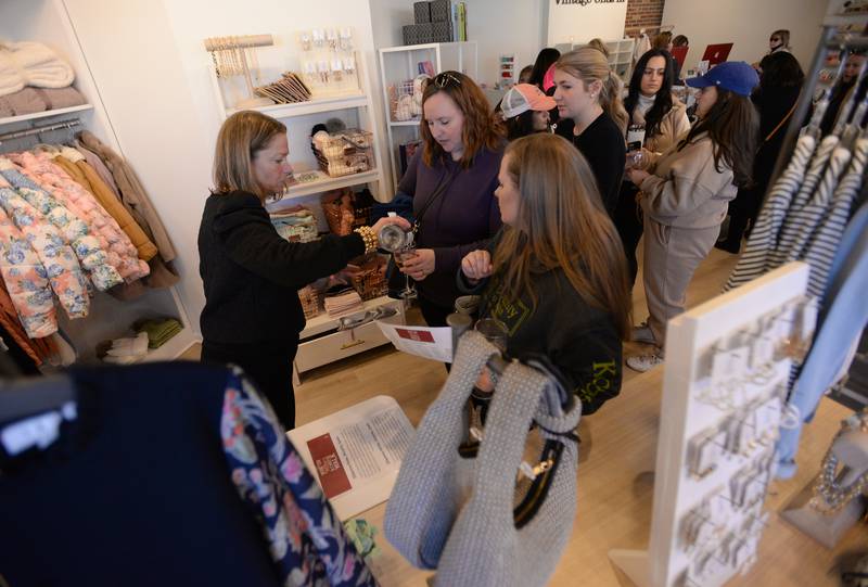 Vintage Charm Store Owner, Beth Maroney serves wine to Winter Wine and Cheese Walk attendees (left) Danielle Hernandez of Newark and Ingrid Fanella of Wheaton  Saturday, Feb 3, 2024.